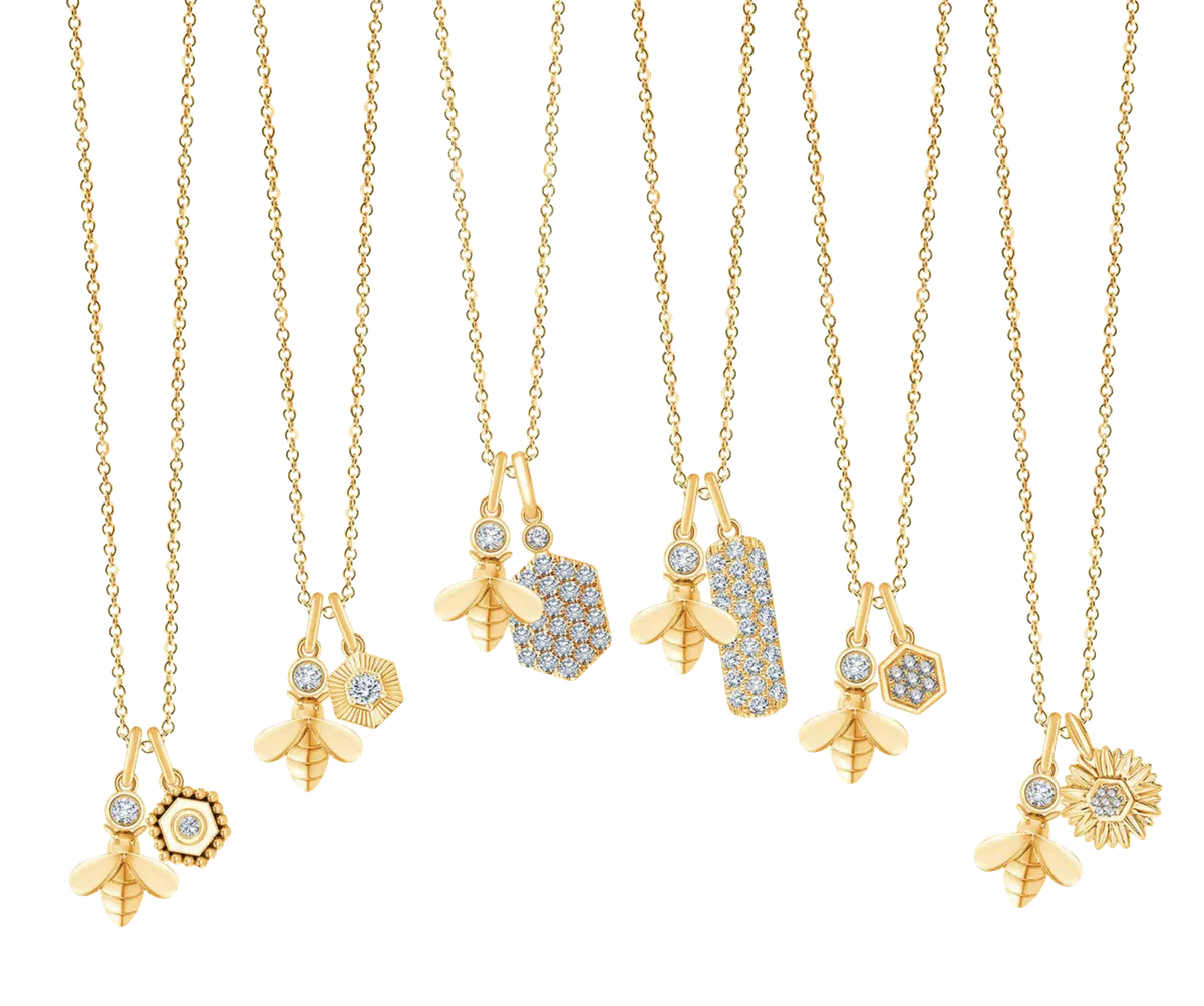 Six gold chain necklaces with bee charms and diamond-accented pendants on white background