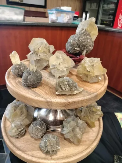 Mineral crystal specimens displayed on a two-tiered wooden stand