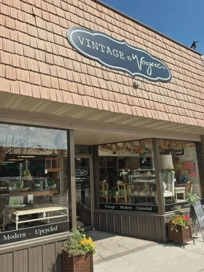 Storefront of Vintage n Vogue shop with cedar shake facade and flower boxes
